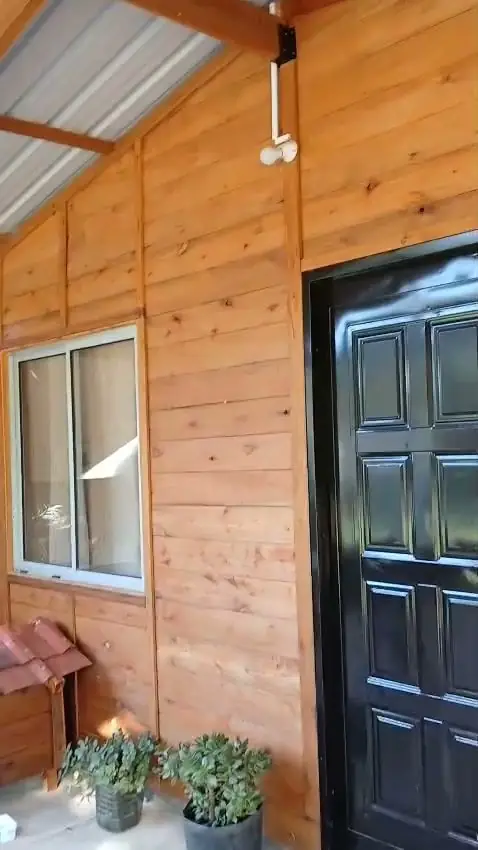 Puerta de entrada y ventana de aluminio en una vivienda de madera
