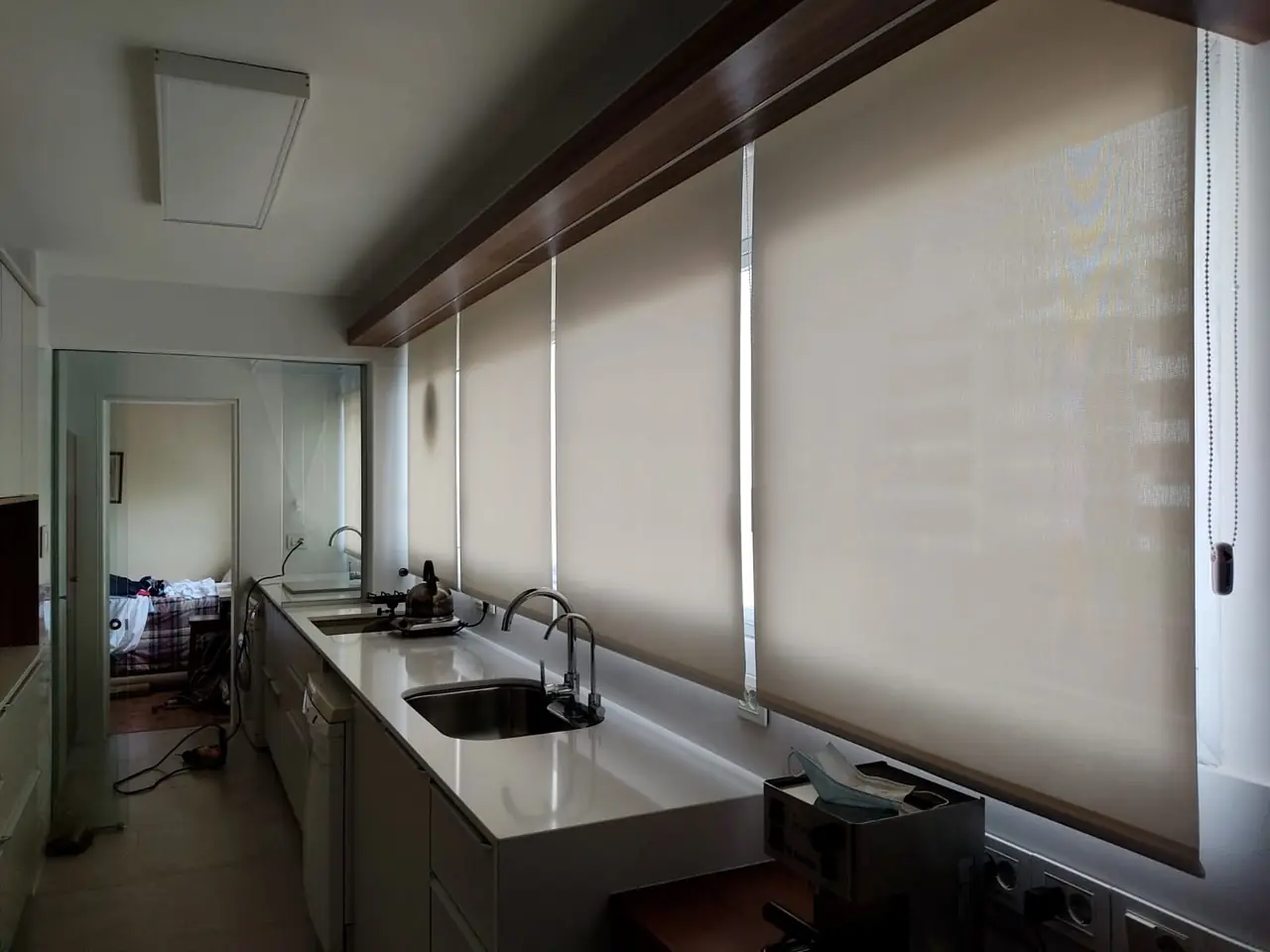 Cocina con cortina roller screen sobre la mesada