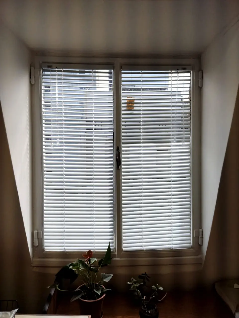 Veneciana de aluminio blanca en una puerta ventana